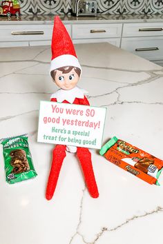 an elf is holding a sign that says you were so good today here's a special treat for being god