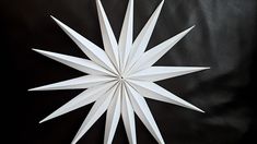 a white paper snowflake sitting on top of a black surface