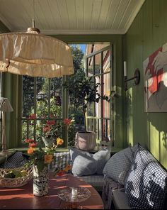 a room with green walls and wooden flooring, an umbrella hanging from the ceiling