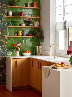 a kitchen with green wallpaper and wooden cabinets