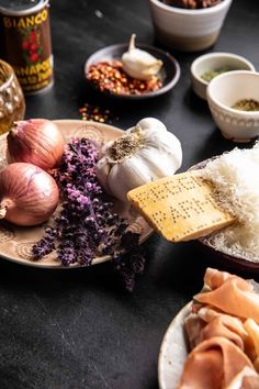 an assortment of food on a plate with seasonings and spices in bowls next to it