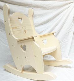 a wooden rocking horse with hearts cut out of it's back and seat, on a white background