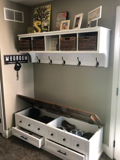 there is a white shelf with baskets on it and other items in the bins