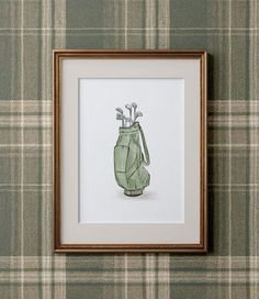 a green vase with golf tees in it on a plaid wallpapered background