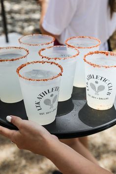 a person holding a tray with drinks on it