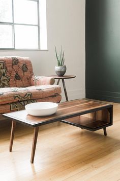 a coffee table with a bowl on it next to a couch