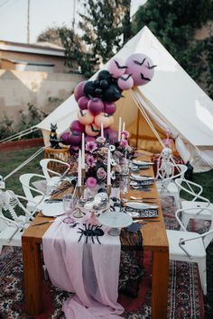 a table set up with balloons and decorations