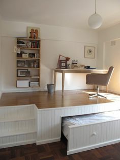 a room with a bed, desk and bookshelf on the wall next to it