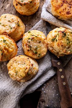 several small muffins sitting on top of a cloth next to a knife