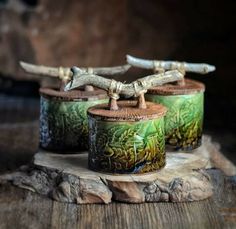 three wooden containers sitting on top of a piece of wood with birds painted on them