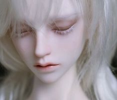 a white doll with blonde hair and eyes closed