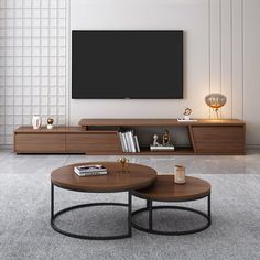 a living room with two coffee tables and a television on the wall above it, in front of a large window