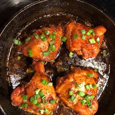 chicken wings with green onions in a skillet