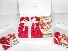 a box filled with red roses next to two boxes of cookies and candies in them