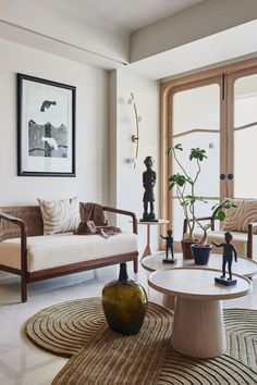 a living room with two couches and a table in front of a large window