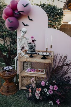 a table topped with lots of cakes and halloween decorations