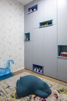 a child's playroom with blue shelves and toys on the floor in front of it