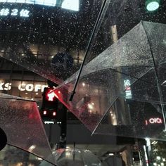 the umbrellas are hanging upside down in the air outside at night, with rain falling on them