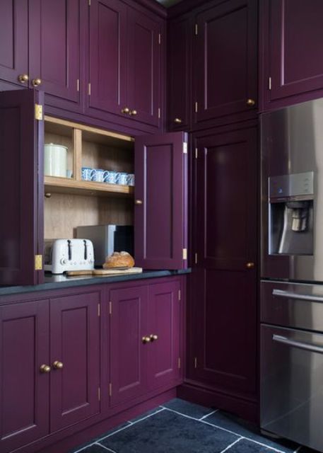 a refined deep purple kitchen with black countertops and niches hidden with folding doors is a very stylish idea Purple Kitchen Cabinets, Violet Kitchen, Kitchen Purple, Purple Kitchen Decor, Purple Cabinets, Kitchen Appliance Storage, White Tile Backsplash, Purple Kitchen, White Kitchen Island