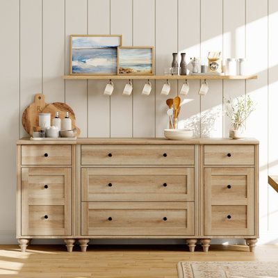 This mid-century-style dresser brings an elegant look to your bedroom with its distressed oak finish and molded detailing. The spacious, low-profile frame is made from a blend of solid and engineered wood. It features multiple drawers that provide ample storage space for your clothes, blankets, and table linens. This versatile dresser is designed to maximize vertical storage in your entryway, dining room, or living room while keeping your essentials in order. The smooth metal slides ensure easy Dresser With Floating Shelves Above, Mixed Wood Bedroom Furniture, Dresser And Night Stand Ideas, Dresser Tv Stand Bedroom, Long Dressers Bedroom, Kitchen Chest Of Drawers, Farmhouse Bedroom Dresser, Driftwood Dresser, Tv For Bedroom