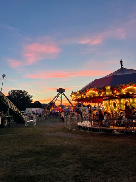 vertical photo of a sunset behind a lit up merry go round and other carnival rides Nature, Fair Aesthetic Fall, Small Town Carnival Aesthetic, Carnival Fair Aesthetic, Midwest America Aesthetic, Fall Small Town, 90s Town Aesthetic, Summer In A Small Town Aesthetic, Small Town Festival Aesthetic