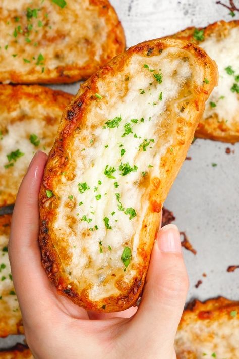 A lovely slice of cheesy garlic bread in a hand over a sheet of garlic bread Best Cheesy Garlic Bread, Homemade Garlic Bread Recipe, Cheesy Garlic Bread Recipe, Homemade Garlic Bread, Garlic Bread Recipe, Cheesy Garlic Bread, Idee Pasto, Best Italian Recipes, Makanan Diet