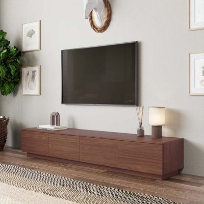 Deciding between storage or style in the living room? Get both with this walnut TV console. Ideal for a modern vibe, the long entertainment center adds style and function to your space. It features a large size, ample storage, and a wood grain finish. With a walnut finish and 4 roomy drawers, this modern entertainment center is a storage piece and a work of art. Overall Entertainment Center Width - Side to Side: 75" W, Color: Brown | Hokku Designs Comerico Modern Wood TV Stands, Minimalist Long 72 Inch Tv Stand, Minimalist Media Console, Tv Drawers, Tv Drawer, Long Media Console, Tv Unit With Drawers, Walnut Tv Cabinet, Tv Stand Minimalist, Wood Tv Stands