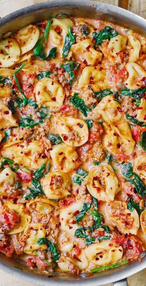 Creamy Tortellini with Sausage, Spinach, Tomatoes, and Mozzarella in a stainless steel skillet Andouille Sausage Tortellini Crockpot, Creamy Tortellini Casserole, Spinach Sausage Tortellini Pasta, Creamy Tortellini With Spinach & Tomatoes, Tortellini With Chicken Sausage, Tortellini Chicken Sausage Recipes, Pasta And Spinach Recipes Easy Dinners, Spinach And Sausage Tortellini, Costco Cheese Tortellini Recipes