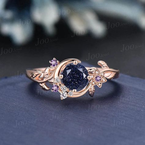 Nature Inspired Round Galaxy Blue Sandstone Amethyst Wedding Ring Unique Moon Leaf Vine Blue Goldstone Engagement Ring Art Deco Promise Ring Engagement Ring: round cut alexandrite The side stones are amethyst and moissanite Material Metal: 925 sterling silver, Solid 10k/14k/18k gold,platinum This jewelry is made to order, it can be made with any gemstone/metals. 2-3 weeks to finish. Default Shipping method is usps. 30 days non-hassle return policy.For returned items,there may be handcrafting and shipping fee deducted. Engagement Rings Galaxy, Blue Fantasy Ring, Space Themed Wedding Rings, Moon Inspired Engagement Ring, Sandstone Engagement Rings, Cosmic Engagement Ring, Moon Ring Design, Galaxy Ring Engagement, Galaxy Wedding Ring