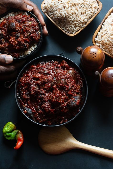 How to Make Ofada Stew (Nigerian Ofada Sauce Recipe) - top view of one dished bowl of ofada rice and stew and another held by two hands with two wooden bowls of ofada rice on the side Essen, Ofada Sauce, Ofada Stew, Rice And Stew, Ofada Rice, Nigerian Stew, Nigeria Food, Countryside Aesthetic, African Recipes Nigerian Food