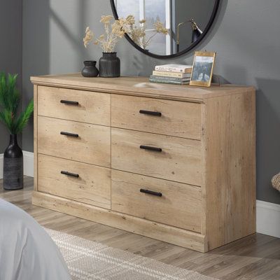 A cottage style dresser in a light and natural finish is the ultimate fresh addition to a bedroom needing a face lift. The 6-drawer dresser from the Aspen Post collection offers stylish storage and easy function. This bedroom dresser features six spacious drawers that open and close on smooth metal runners, perfect for storing the fluffiest flannel PJS and thickest sweaters, or extra bed sheets and thick, soft, downy blankets. The sturdy and spacious surface of this double dresser gives ample ro Prime Oak, Flannel Pjs, Drawer Bedroom, Style Dresser, Storage Cabinet Shelves, Bedroom Dresser, Wood Dresser, Bedroom Furniture Dresser, Double Dresser