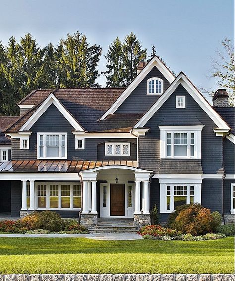 A traditional exterior feels even more timeless thanks to the navy paint accented with crisp white for contrast. Stone Porches, Gray House, Haus Am See, Lots Of Windows, Cape Cod House, Casas Coloniales, Farmhouse Exterior, House Paint Exterior, Exterior Paint Colors