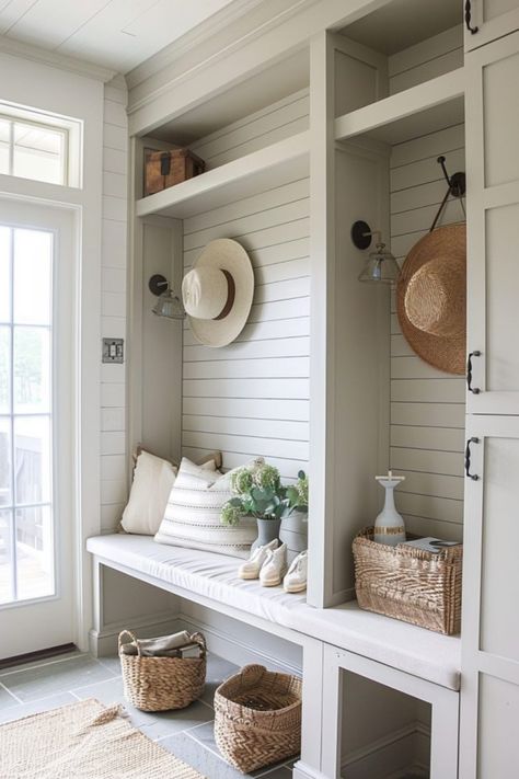 Cozy entryway with built-in seating and storage, featuring neutral tones, wicker baskets, and decorative hats on hooks. Tumblr, Mudroom With Vaulted Ceiling, Beach House Mud Room, Breezeway Mudroom, Kitchen Cabinet Hacks, Farmhouse Mudroom Ideas, Mudroom Designs, Farmhouse Mud Room, Cabinet Hacks