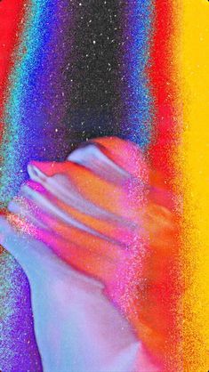 an abstract photo of a person's hand with multicolored paint