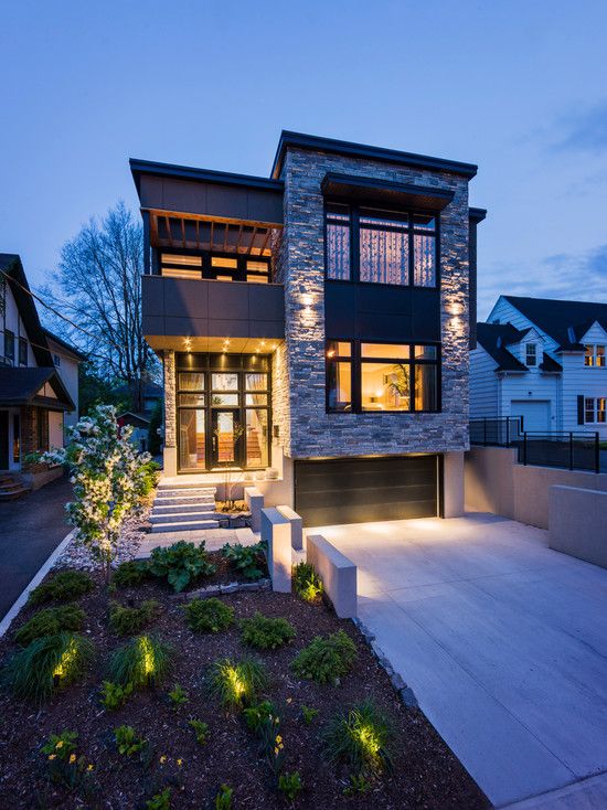 a modern house with lights on the front and side