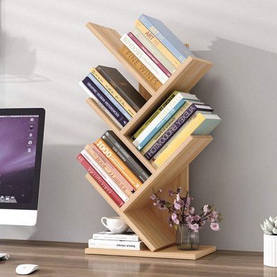 a bookshelf with several books on top of it and a vase filled with flowers