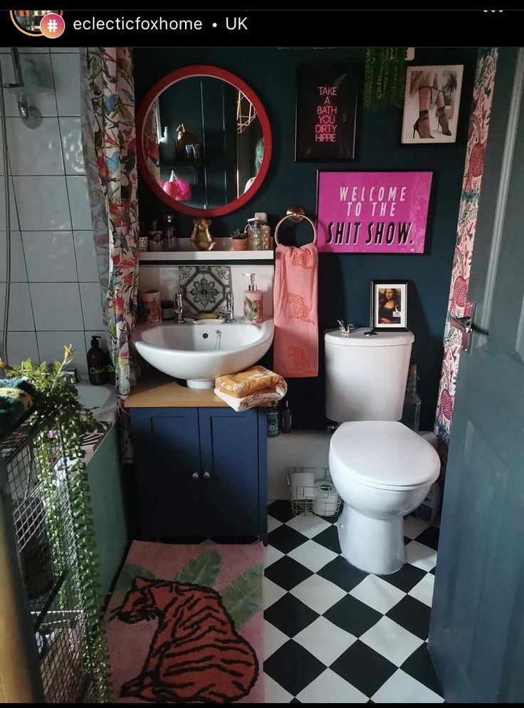 a bathroom with black and white checkered flooring, green walls and pink accents