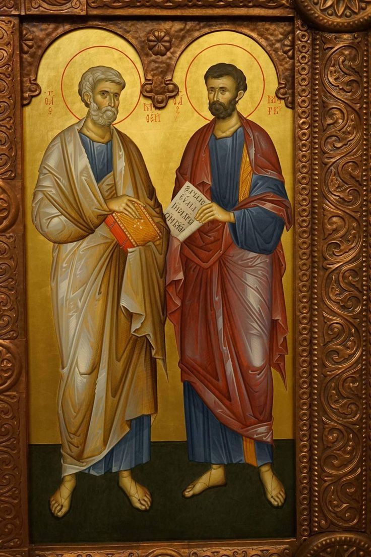 two men standing next to each other in front of a painting