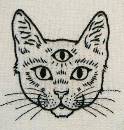 a black and white drawing of a cat's face on a piece of cloth