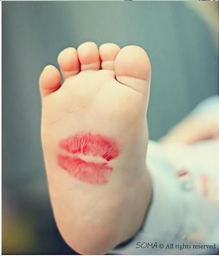 a baby's foot with pink lipstick on it