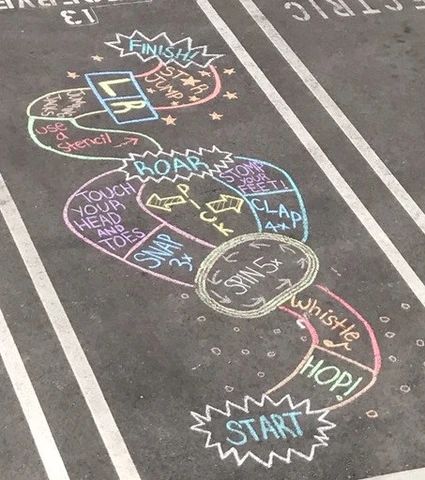 an empty parking lot with chalk drawings on it