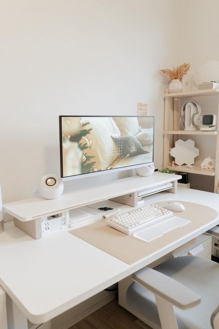 a white desk with a computer monitor and keyboard