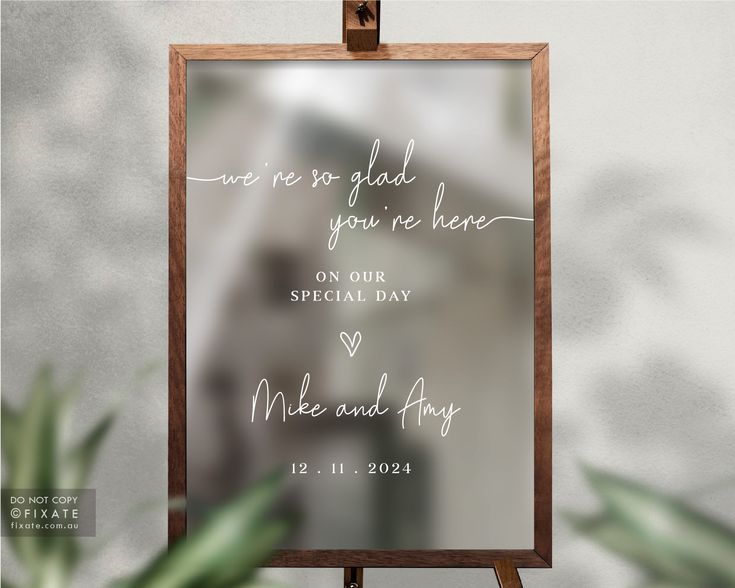 a wooden easel holding a sign that says we are glad you're here on our special day