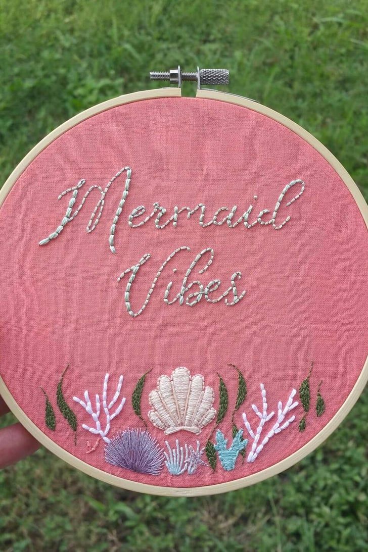 someone is holding up a pink embroidery kit with the words mermaid ales on it