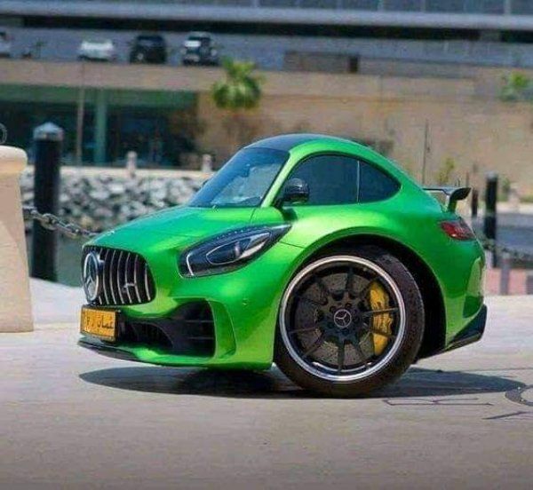 a green sports car parked in front of a building