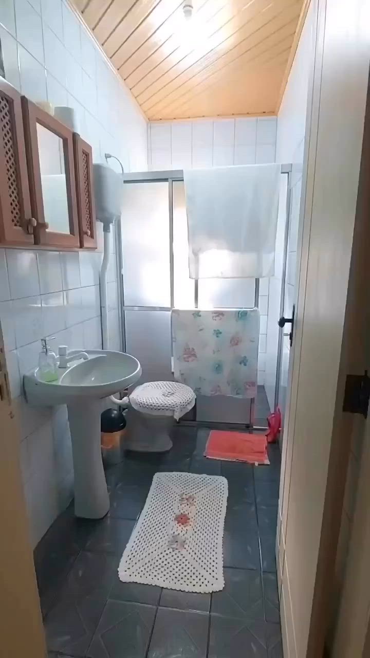 This may contain: a bathroom with a toilet, sink and shower stall