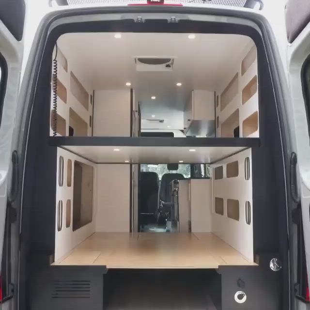 This may contain: the interior of a white van with wood flooring and storage compartments on it's side