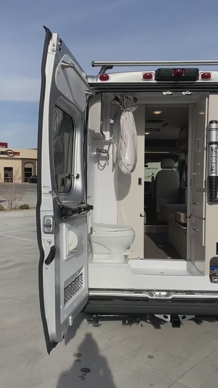 This may contain: the interior of an rv parked in a lot with its door open and toilet inside