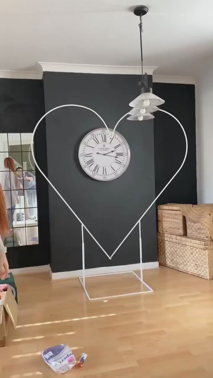 This may contain: two women sitting on the floor in front of a heart shaped clock and boxes with magazines