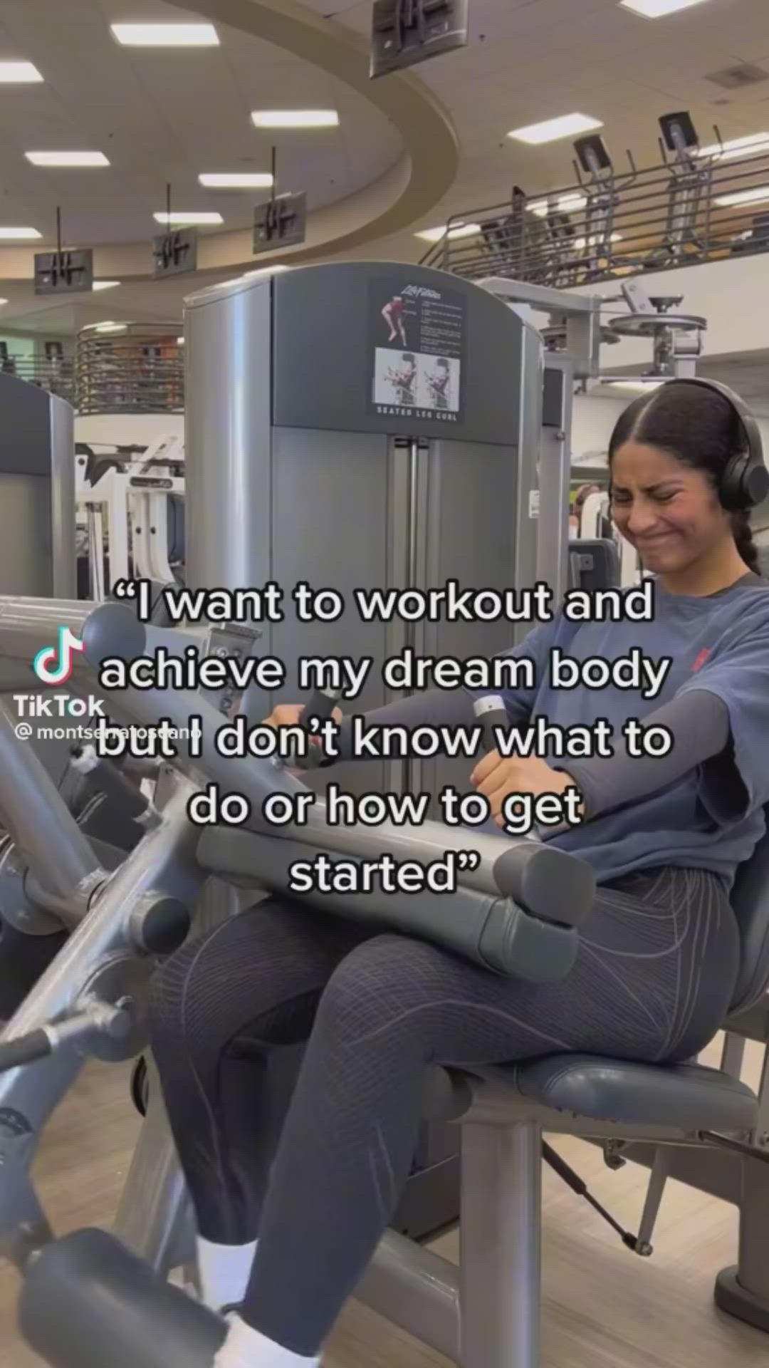 This may contain: a woman sitting on top of a gym machine with headphones in her ears and an exercise quote